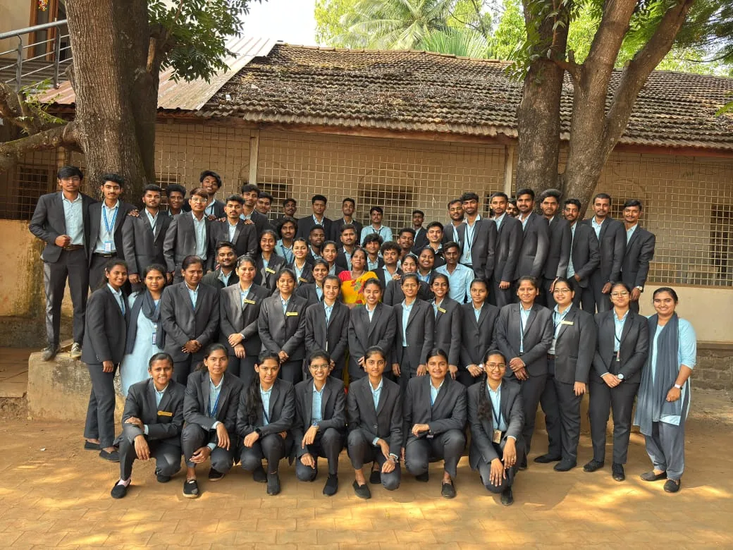 Large group photo of BBA students in formal blazers with Lijoys Solutions trainer at a campus in Karnataka